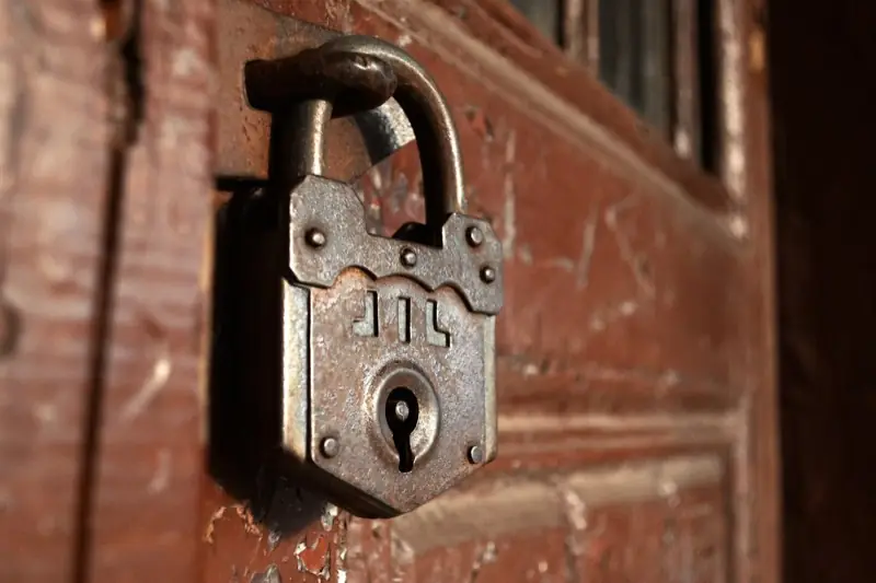 Old rusty padlock on a wooden door