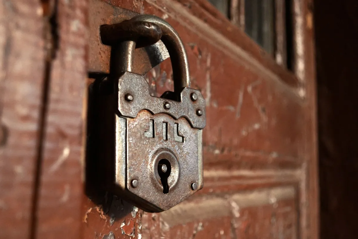 Old rusty padlock on a wooden door