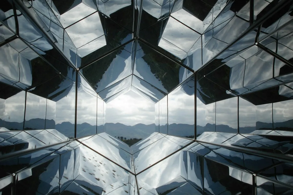 Hexagonal tunnel of mirrors reflecting a mountain range