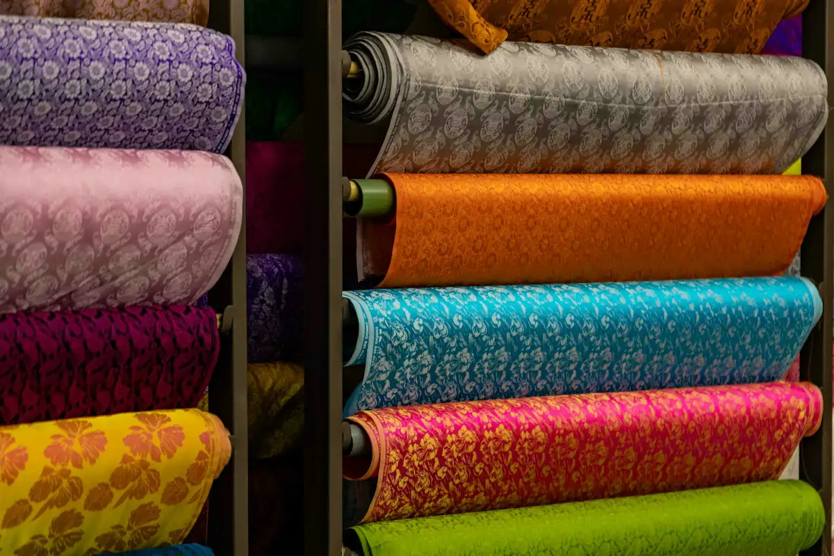 Stacks of colourful patterned fabric rolls on shelves