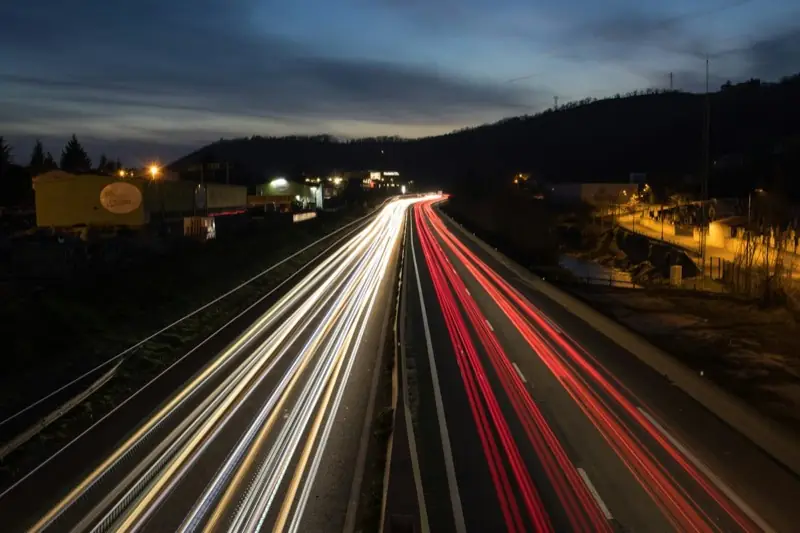 Car headlights streaking along a highway at night