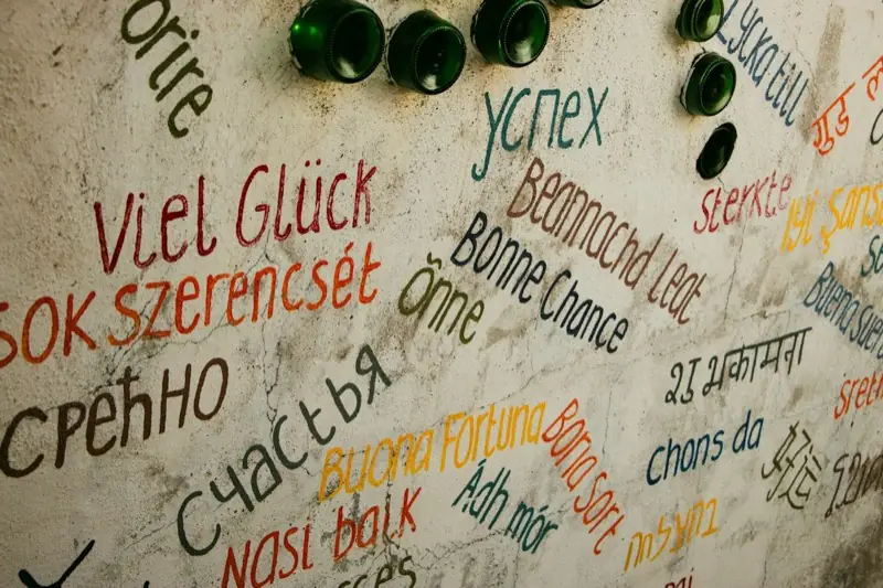 Auguri scritti in molte lingue diverse su un muro